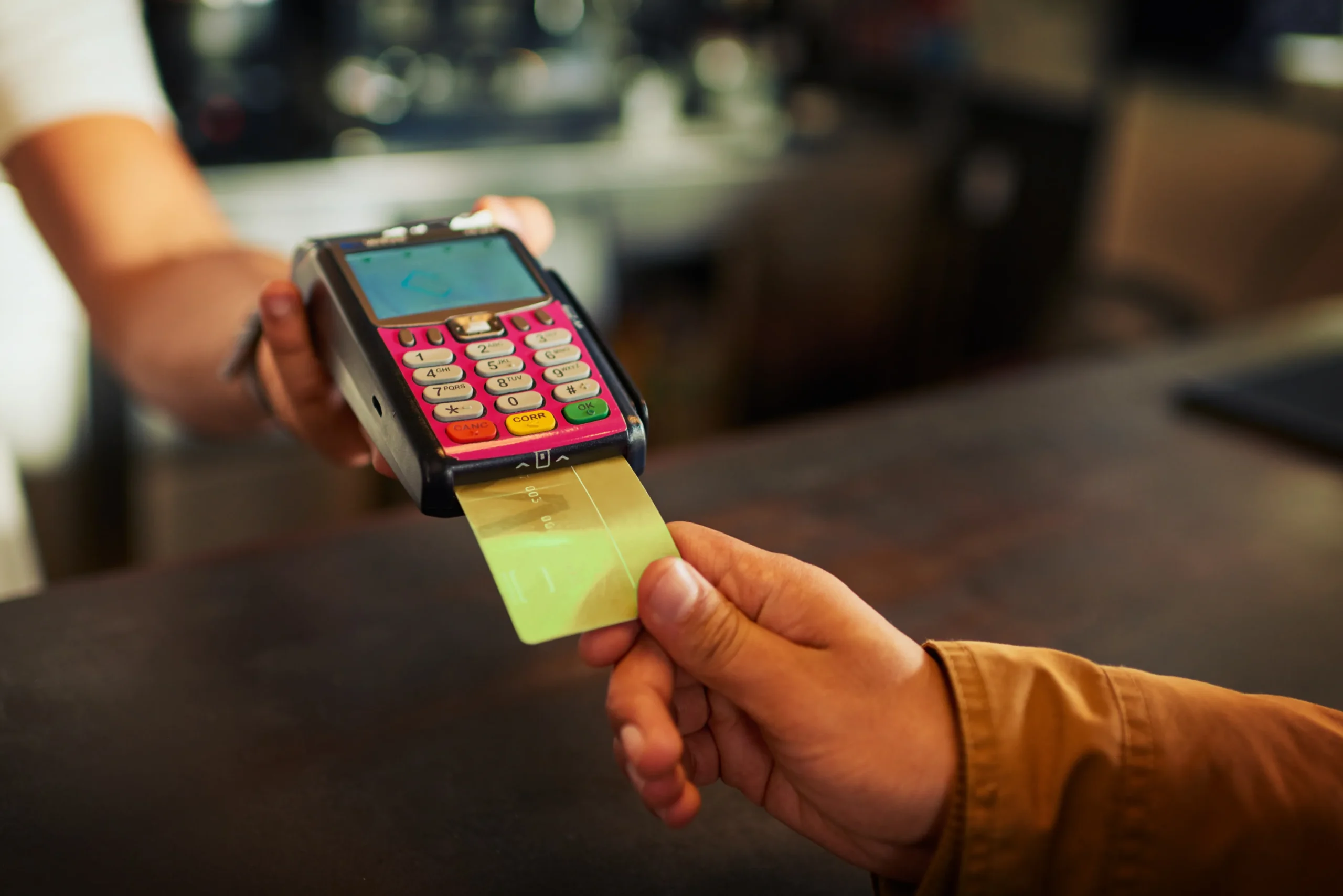 Cashier accepting a digital payment on a card terminal